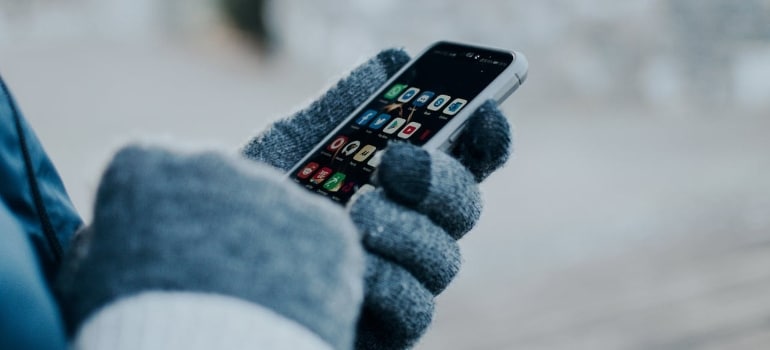 a person with gloves holding the phone and checking about Shipping Container Services