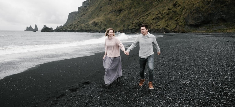 a couple holding hands at the beach