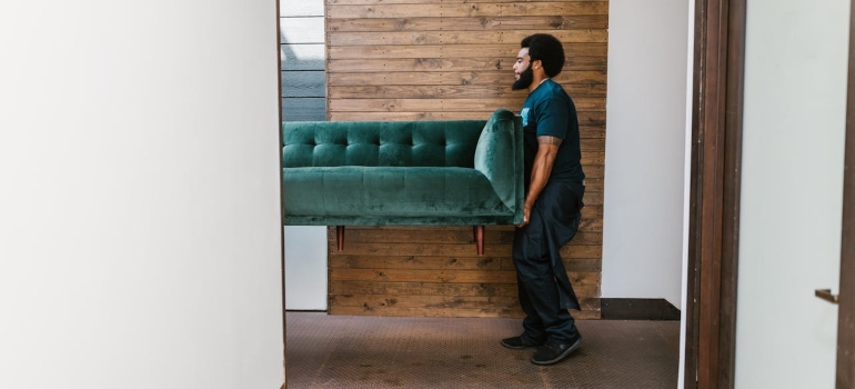 a man holding a sofa 