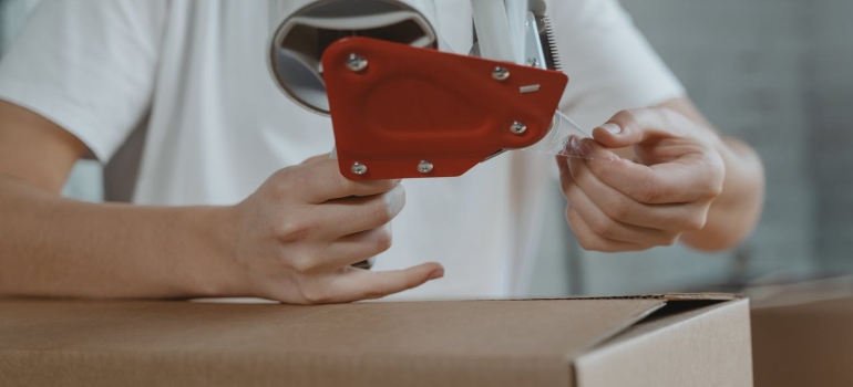 a girl duck taping a box