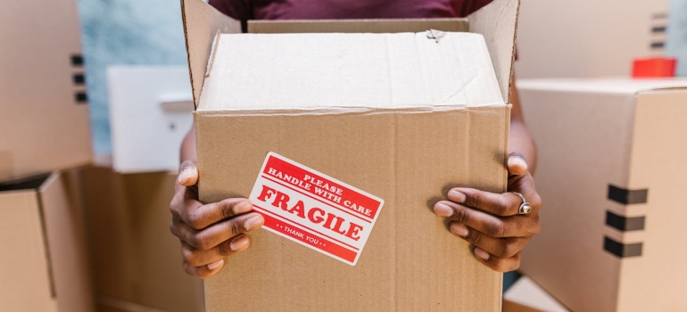 a woman carries a fragile box