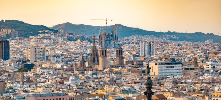 A panoramic view of Barcelona with the iconic Sagrada Família at sunset, showcasing the city’s architectural beauty.