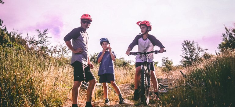 A father and his sons prepare for a bike ride along scenic trails in New Zealand.