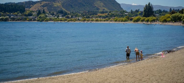 A family enjoys a peaceful day by a lake, a glimpse of life after moving to New Zealand with family in 2025.