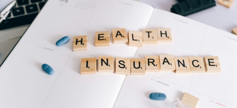 Wooden blocks on a paper that say: "HEALTH INSURANCE".