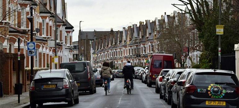 couple riding bikes through one of the best London neighborhoods for expats