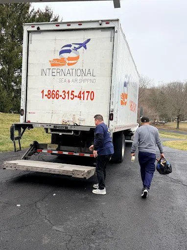 International Sea & Air Shipping movers at the back of a moving truck